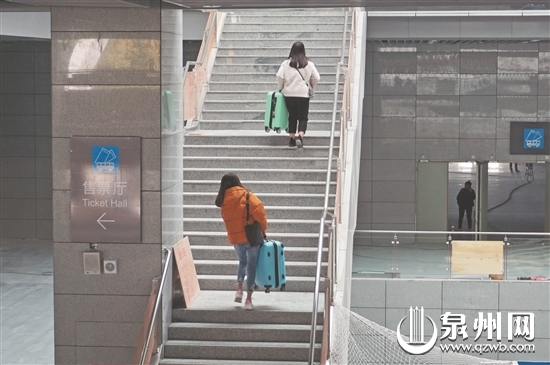 从公交站到动车站，需要经过一段楼梯，乘客扛行李很吃力。