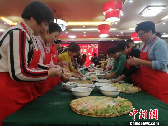 年夜饭，特指农历除夕晚餐，作为中国人一年中最隆重的一顿饭，不仅象征着团圆和亲情，更是一种特有的文化传承。图为游客在孔府包饺子。资料图。　郝学娟 摄