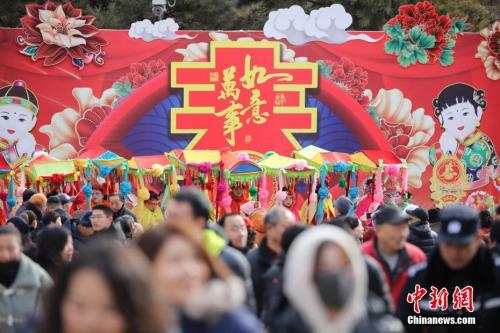 资料图：2月9日，游客在北京八大处公园庙会上游玩，观看传统民间花会表演。 <a target=