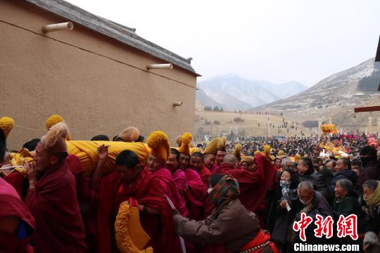 图为来自各地的信众有序跟随着队伍，缓慢移步走向画卷长龙，向大佛上抛献哈达、虔诚膜拜祈福。　纪赟 摄