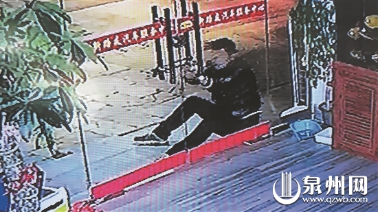 疑犯在撬店面玻璃门的手把