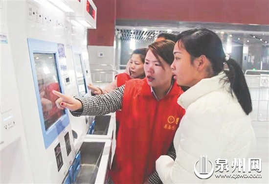 在泉州动车站，青年志愿者引导乘客使用自助购票机。