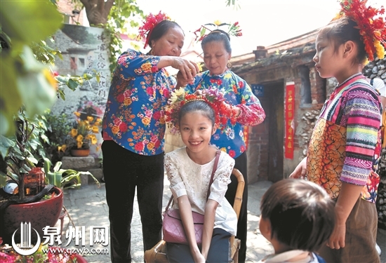 游客在丰泽蟳埔渔村体验蟳埔女传统服饰簪花围。