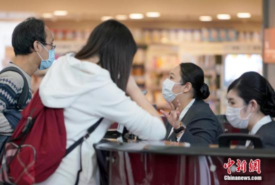 资料图：香港机场近期发生麻疹疫情，香港国际机场的工作人员戴口罩接受旅客问询。<a target=