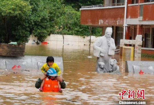 6月10日，江西省龙南县杨村镇中心小学一名学童骑在救援人员的肩上，撤离洪水已经涨到一米多深的学校。　叶波 摄