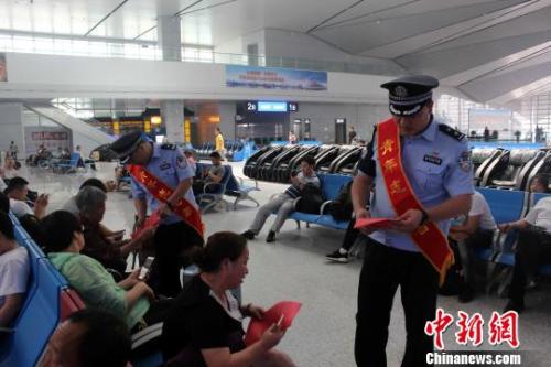 资料图： 青岛铁路公安处民警向旅客发放安全宣传资料。　梁西征 摄