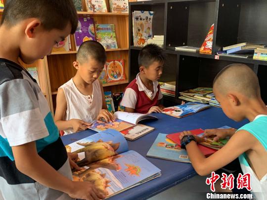书屋内正有三五成群的小朋友们各自读着自己喜欢的漫画书、小说。　刘小红 摄