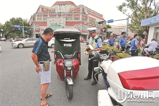 交警对违规上路的电动三轮车进行处罚