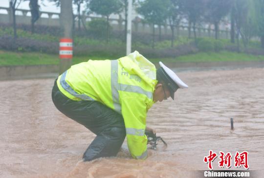 通江县一名交警清理排水口。　李真宝 摄