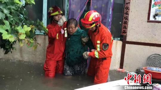 山东省聊城市高唐县消防救援大队队员冒雨转移安置受困人员。　张万福 摄