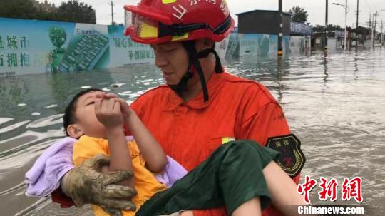 山东省聊城市高唐县消防救援大队队员冒雨转移安置受困人员。　张万福 摄