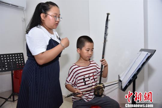 11岁的王若城练习北管多年，已经掌握了唱腔和弦乐演奏。　陈龙山 摄