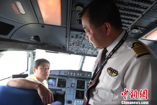 图为王彤起飞前与机组人员沟通飞行方案。　杨艳敏 摄