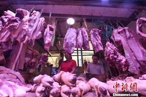 资料图：重庆主城区的一家农贸市场内，商贩正在摆放猪肉。<a target=