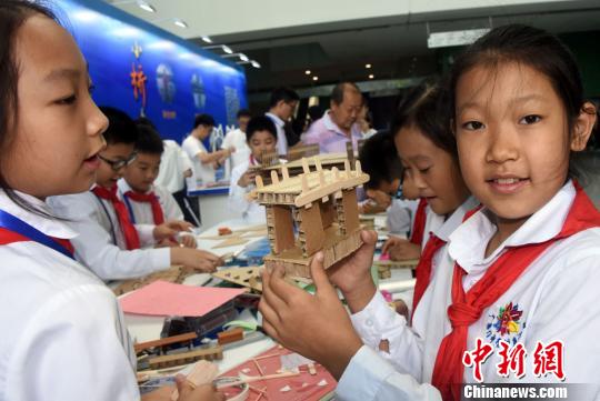 中国科技馆全国科普日活动现场，一名中学生展示她和同学现场用纸板设计制作的大桥桥墩。　孙自法 摄