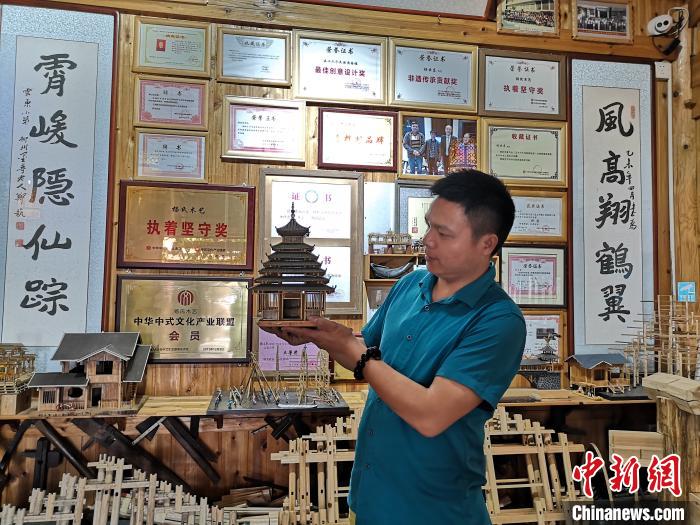 杨云东展示侗族木构建筑模型。　林馨 摄