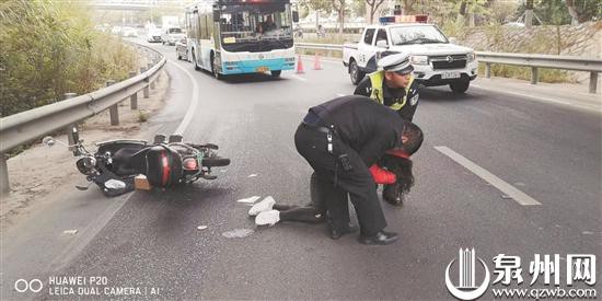 女子骑车打滑摔倒，交警帮忙扶起。