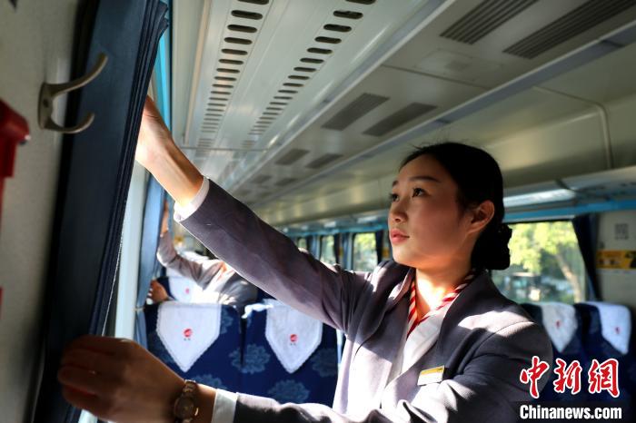 福州至北京K46次乘务员整理刚换上的窗帘。　李一明 摄