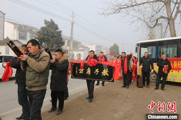 双沟镇孟圩村组织人员敲锣打鼓把好媳妇高书兰获得的“教子有方”牌匾送到安徽省灵璧县朝阳镇杨桥村的娘家。　吕丁 摄