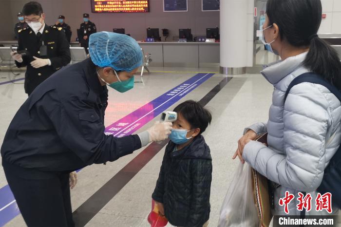 在福建泉州晋江国际机场，旅检关员为旅客测量体温。　孙虹 摄