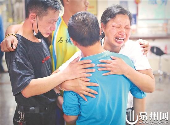 昨日在泉州市救助站，从江西赶来的张满堂夫妻与失散的儿子“来弟”重聚，喜极而泣。（王柏峰 摄）
